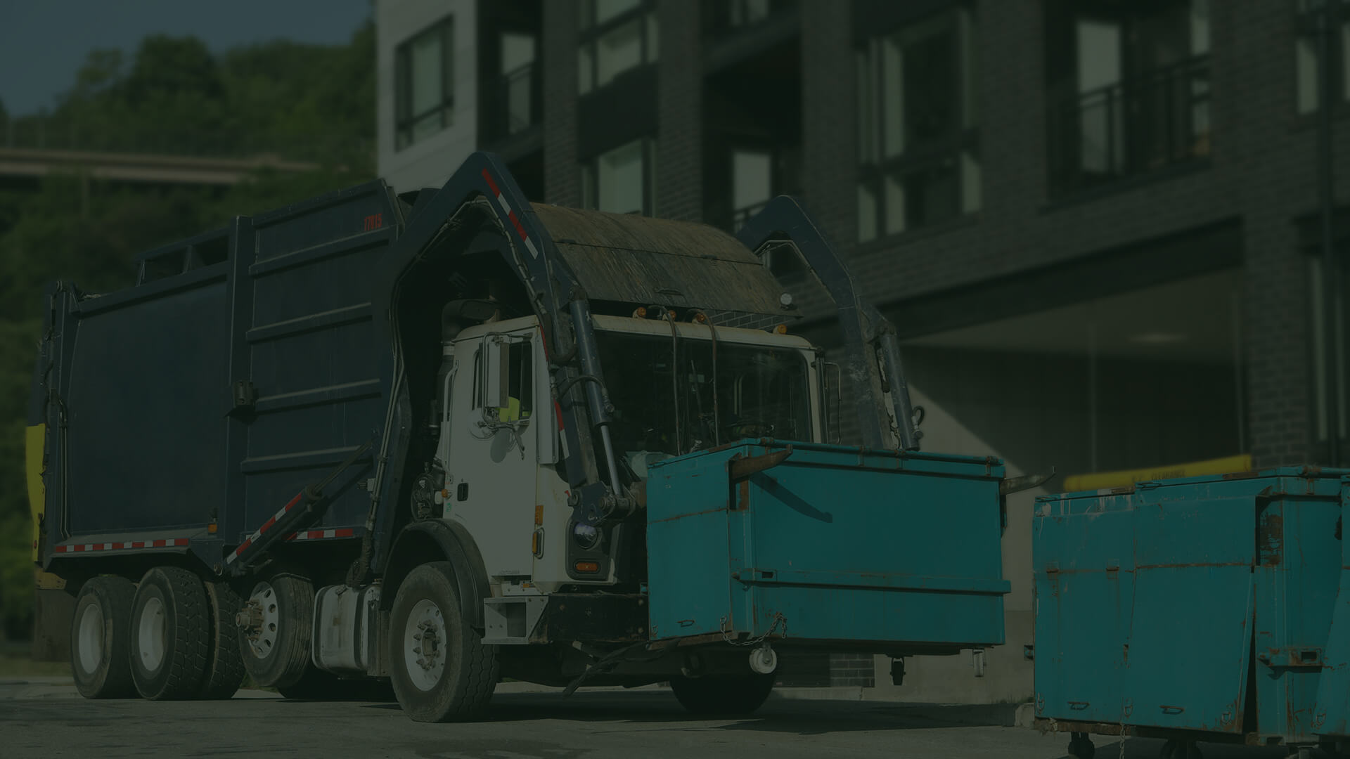 A truck picks up a dumpster container
